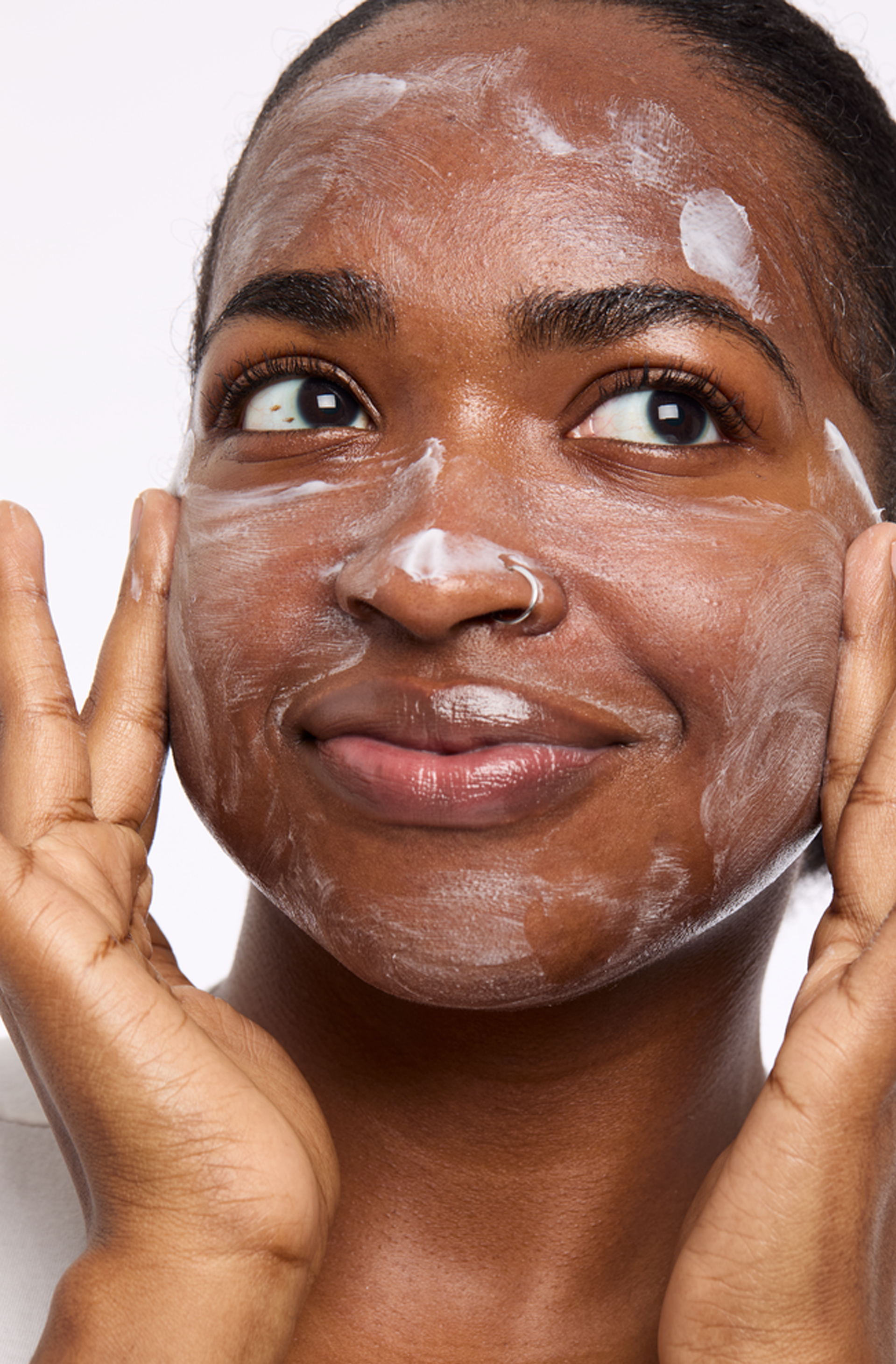 Une personne tient ses mains près de son visage, les paumes tournées vers l'extérieur, et utilise un nettoyant Mary Kay pour se laver le visage.